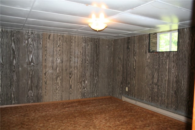 basement featuring baseboard heating and wood walls