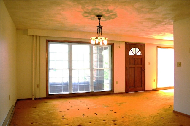 entryway featuring a notable chandelier and light carpet