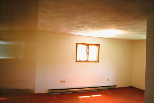 spare room featuring a textured ceiling and a baseboard heating unit