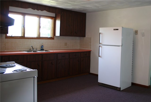 kitchen with decorative backsplash, sink, dark brown cabinets, and white refrigerator