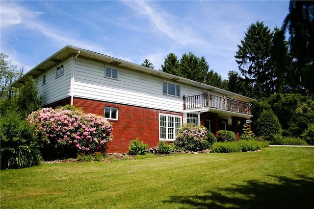 back of house with brick siding and a yard