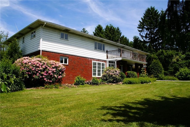 back of house featuring a yard and brick siding