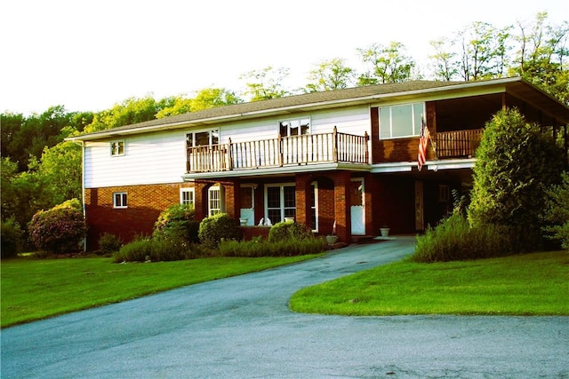 view of front of house with a front lawn and a balcony