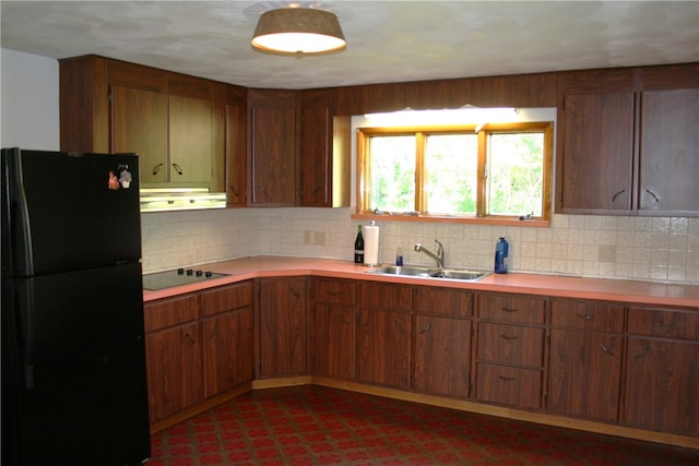 kitchen featuring backsplash, sink, black appliances, and ventilation hood