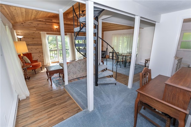 dining room with wood walls, a baseboard radiator, lofted ceiling, and hardwood / wood-style floors