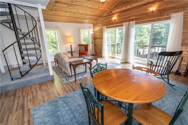 dining space with wood walls, hardwood / wood-style flooring, vaulted ceiling, and wooden ceiling