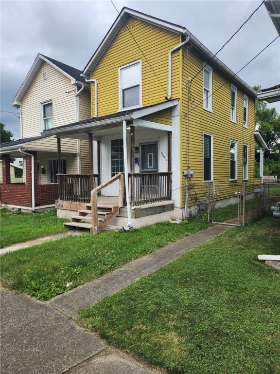 view of front of home featuring covered porch and a front lawn