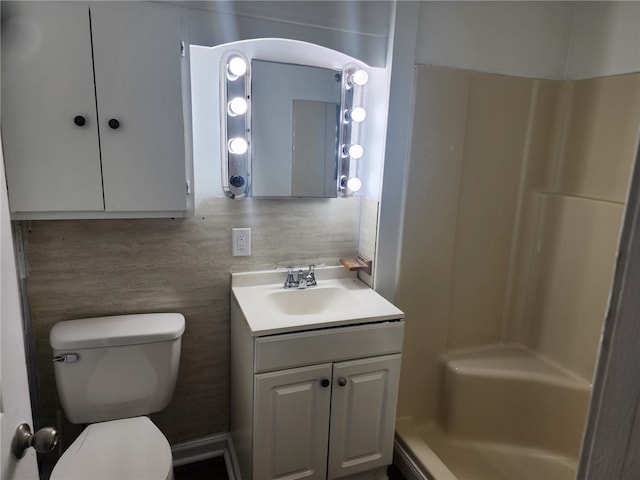 bathroom featuring a shower, vanity, backsplash, and toilet