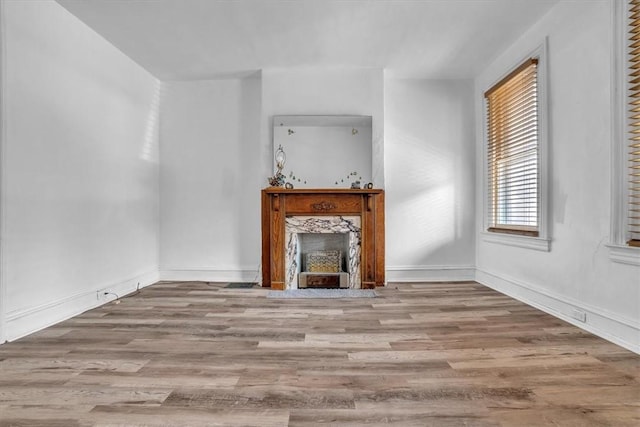 unfurnished living room featuring a fireplace and light hardwood / wood-style flooring