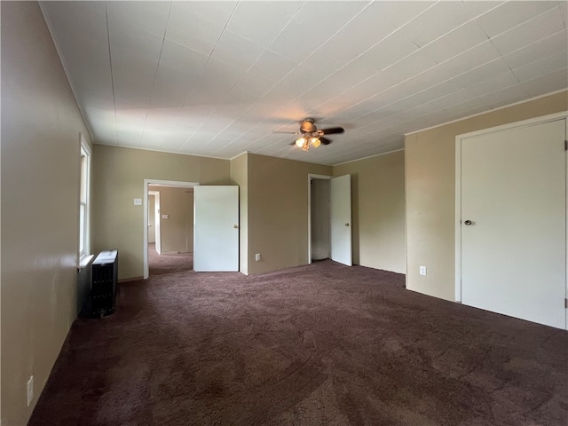 unfurnished room featuring dark colored carpet and ceiling fan