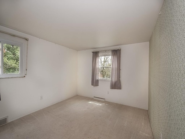 carpeted spare room featuring a baseboard heating unit