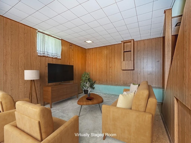 carpeted living room featuring wooden walls