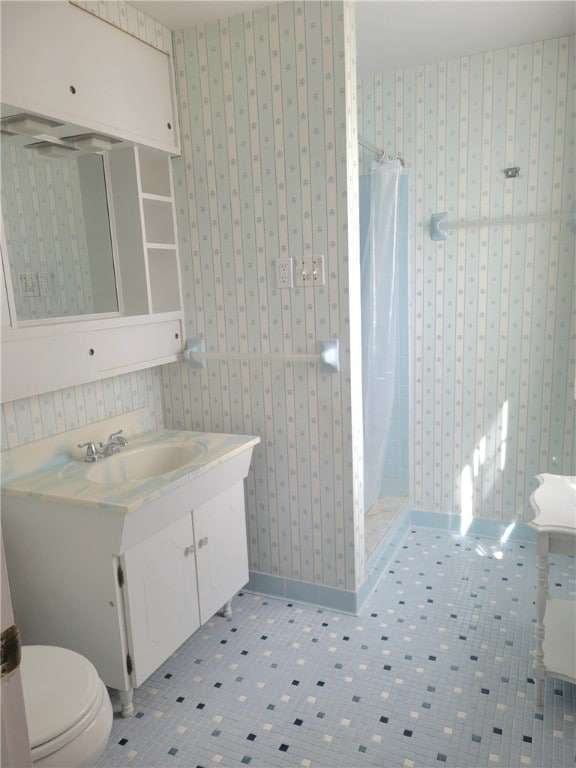 bathroom featuring tile patterned flooring, a shower with curtain, vanity, and toilet