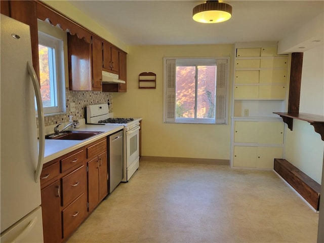 kitchen featuring backsplash, sink, and white appliances