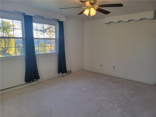 carpeted spare room featuring a baseboard radiator and ceiling fan