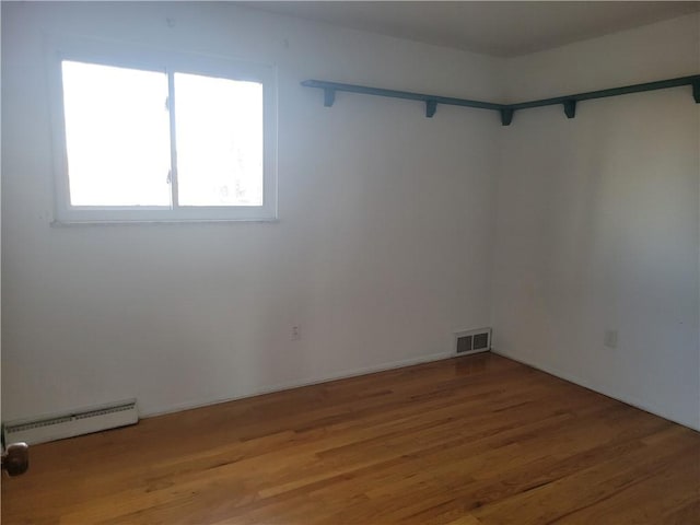 spare room featuring hardwood / wood-style flooring and a baseboard radiator