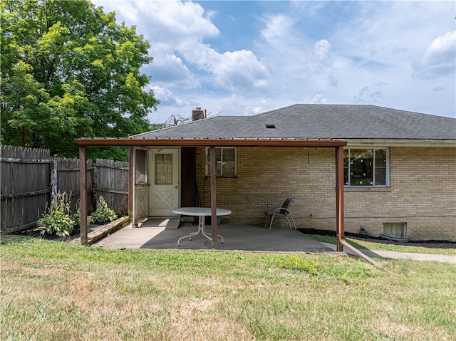 rear view of property featuring a patio and a lawn