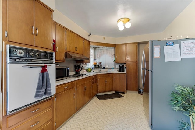 1120 Henderson Ave, Canton Twp, PA 15301 - kitchen featuring appliances with stainless steel finishes, under cabinet range hood, brown cabinetry, and light countertops