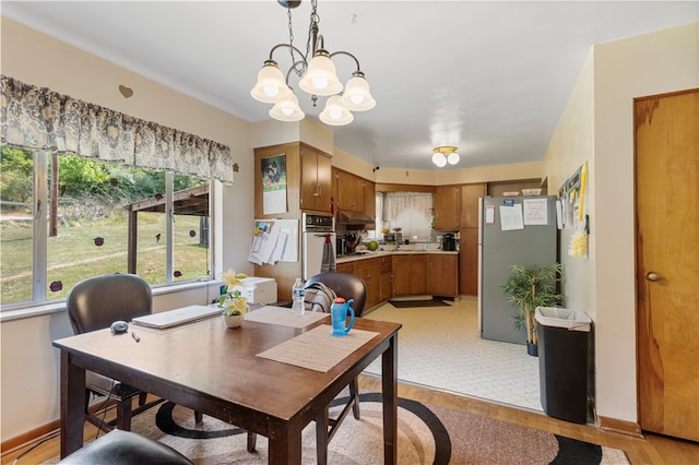 dining area with an inviting chandelier and light hardwood / wood-style flooring