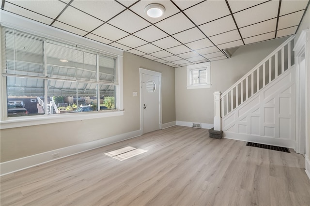 foyer with a paneled ceiling and light wood-type flooring