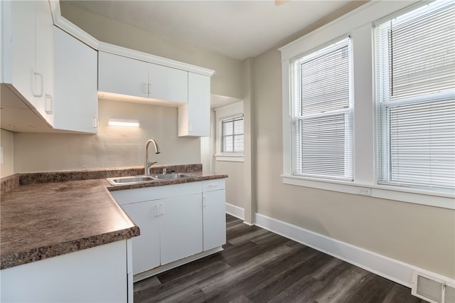 kitchen with white cabinetry, dark wood-type flooring, and sink