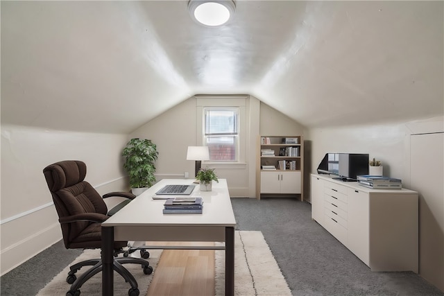 carpeted home office featuring vaulted ceiling