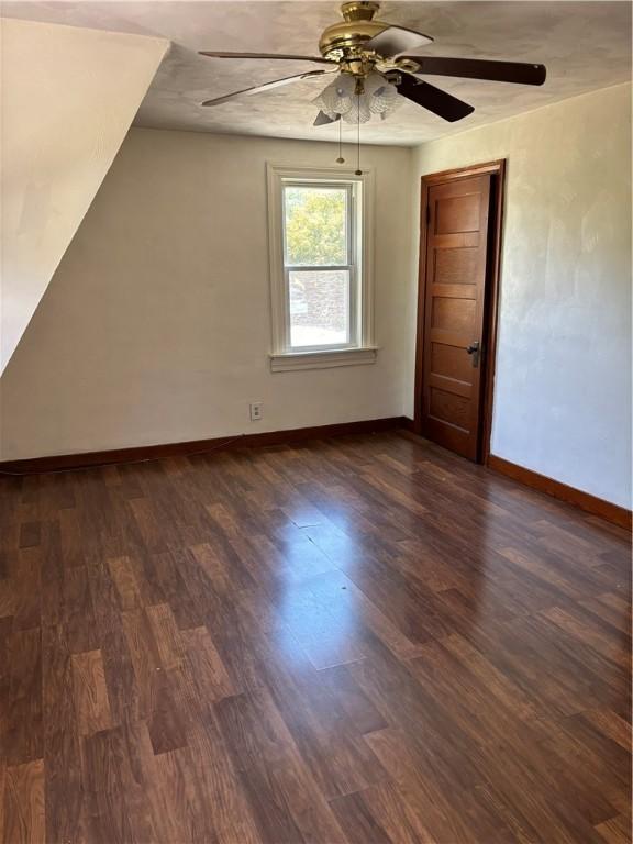 interior space featuring dark wood-type flooring and ceiling fan