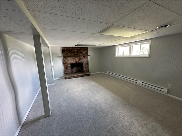 basement with carpet floors, a paneled ceiling, a fireplace, and a baseboard radiator