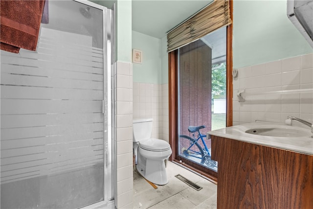 bathroom with tile patterned flooring, tile walls, toilet, and vanity