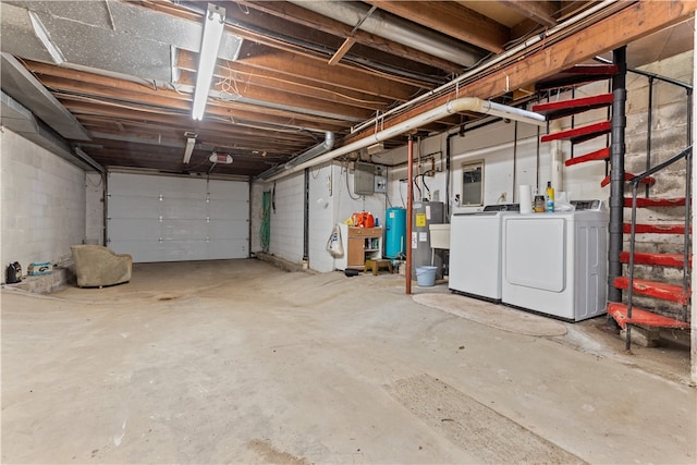 garage featuring washing machine and dryer and water heater