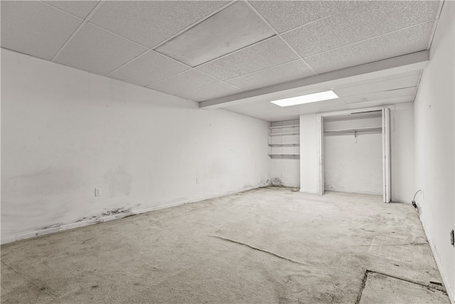 interior space with a paneled ceiling and carpet flooring