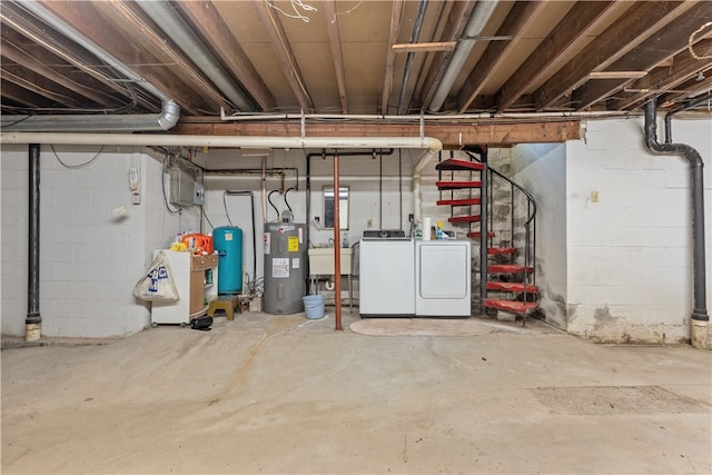 basement featuring electric water heater, sink, and separate washer and dryer