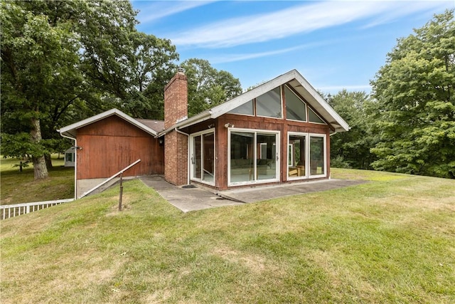 rear view of property featuring a chimney and a lawn