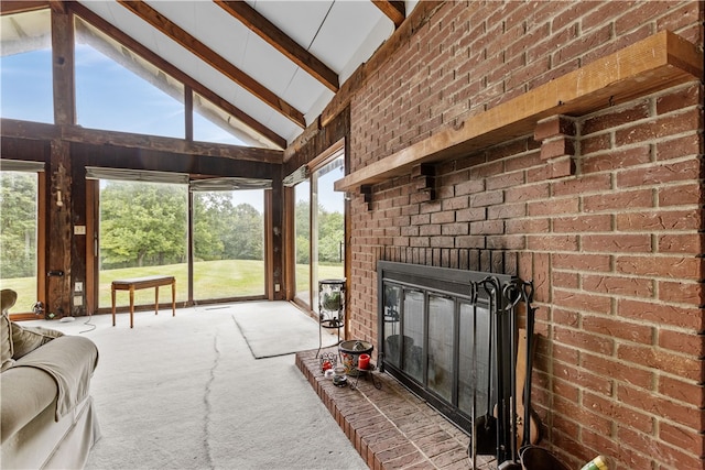 sunroom / solarium featuring a fireplace and vaulted ceiling with beams