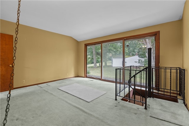 carpeted empty room featuring lofted ceiling