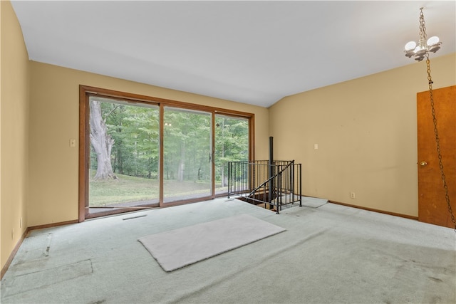 empty room featuring carpet flooring and a chandelier