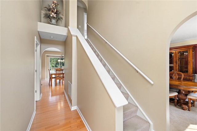 stairway featuring crown molding and wood-type flooring