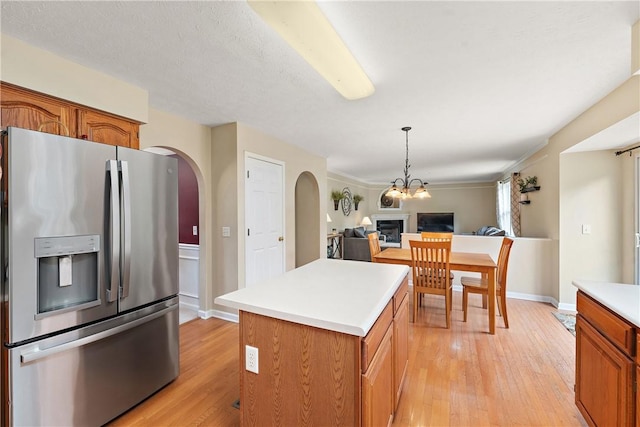 kitchen featuring pendant lighting, stainless steel fridge, a center island, and light hardwood / wood-style floors