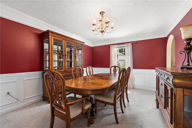 dining room featuring crown molding, light colored carpet, a chandelier, and a textured ceiling