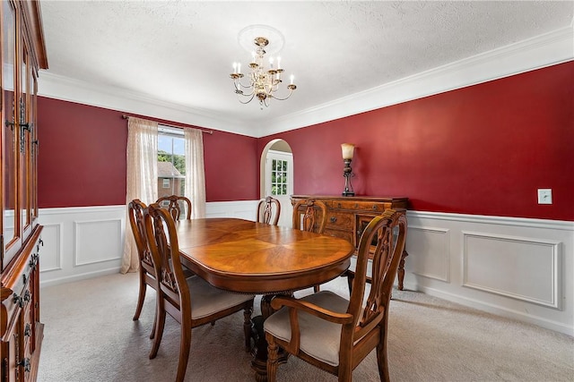 carpeted dining area with crown molding, a notable chandelier, and a textured ceiling