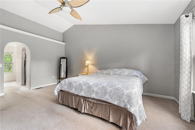 bedroom with ceiling fan, lofted ceiling, and light carpet