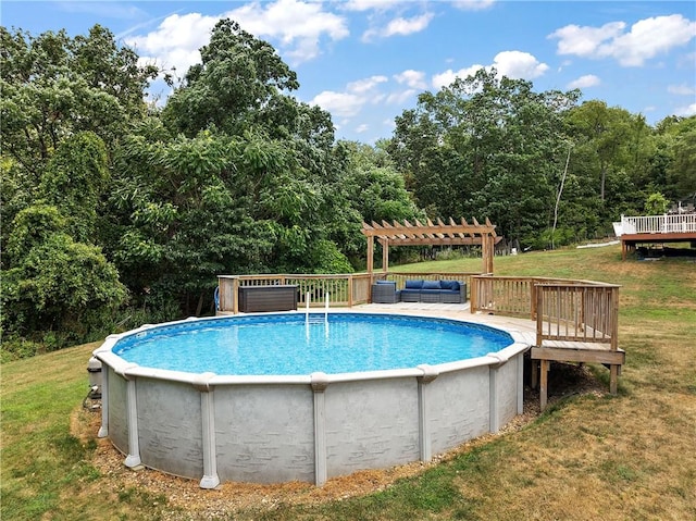 view of pool featuring a wooden deck, a pergola, and a lawn