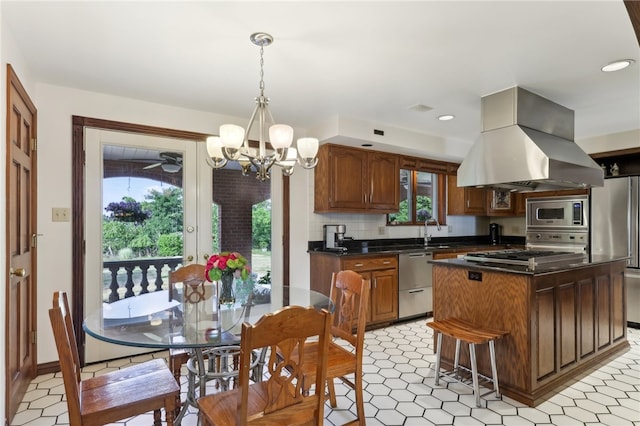 kitchen featuring appliances with stainless steel finishes, light tile patterned floors, extractor fan, and a kitchen island