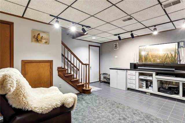 tiled living room with a paneled ceiling and track lighting