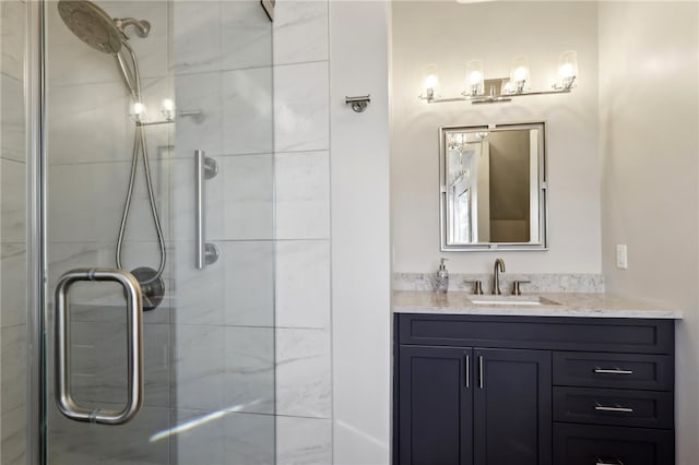 bathroom featuring vanity and a shower with door