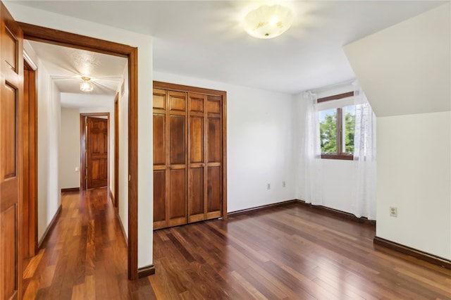 unfurnished bedroom with dark hardwood / wood-style flooring and a closet