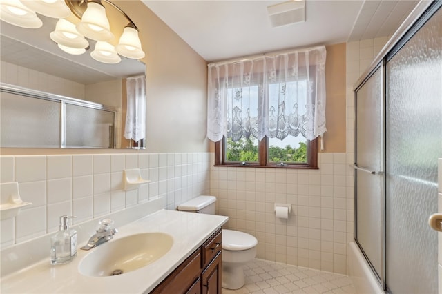 full bathroom featuring tile patterned floors, tile walls, bath / shower combo with glass door, toilet, and backsplash