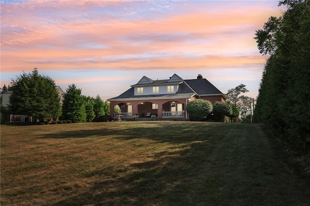 craftsman-style home with covered porch and a lawn