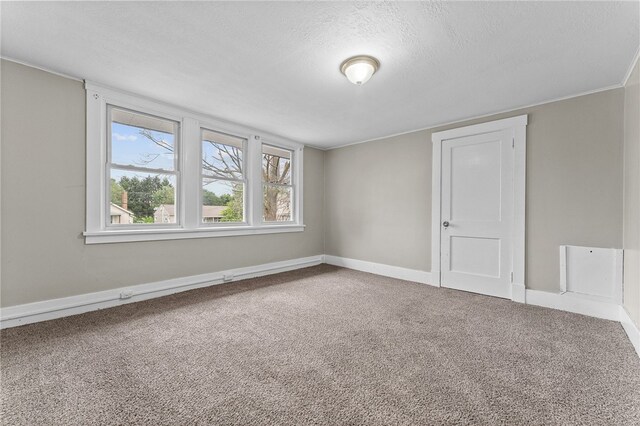 carpeted empty room with a textured ceiling