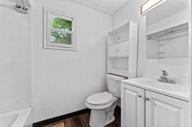 full bathroom with shower / bathtub combination, vanity, hardwood / wood-style flooring, and toilet